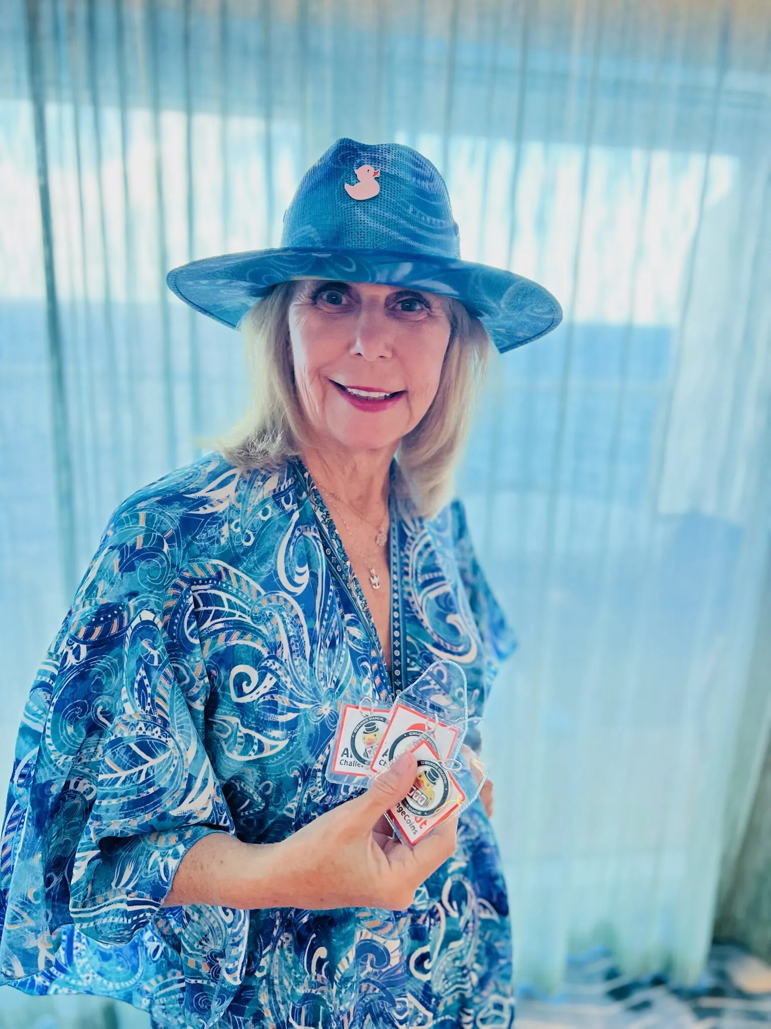 Jackpot Jill in a blue paisley outfit and duck pin hat holds a fan of duck cards.