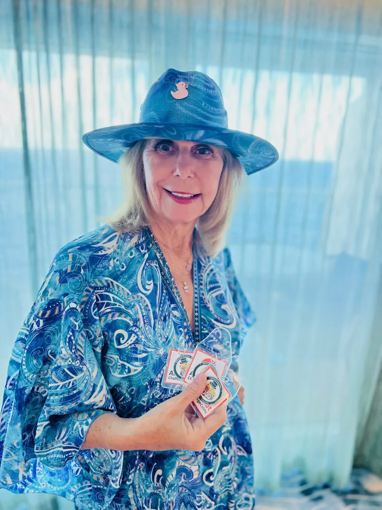 Jackpot Jill in a blue paisley outfit and duck pin hat holds a fan of duck cards.